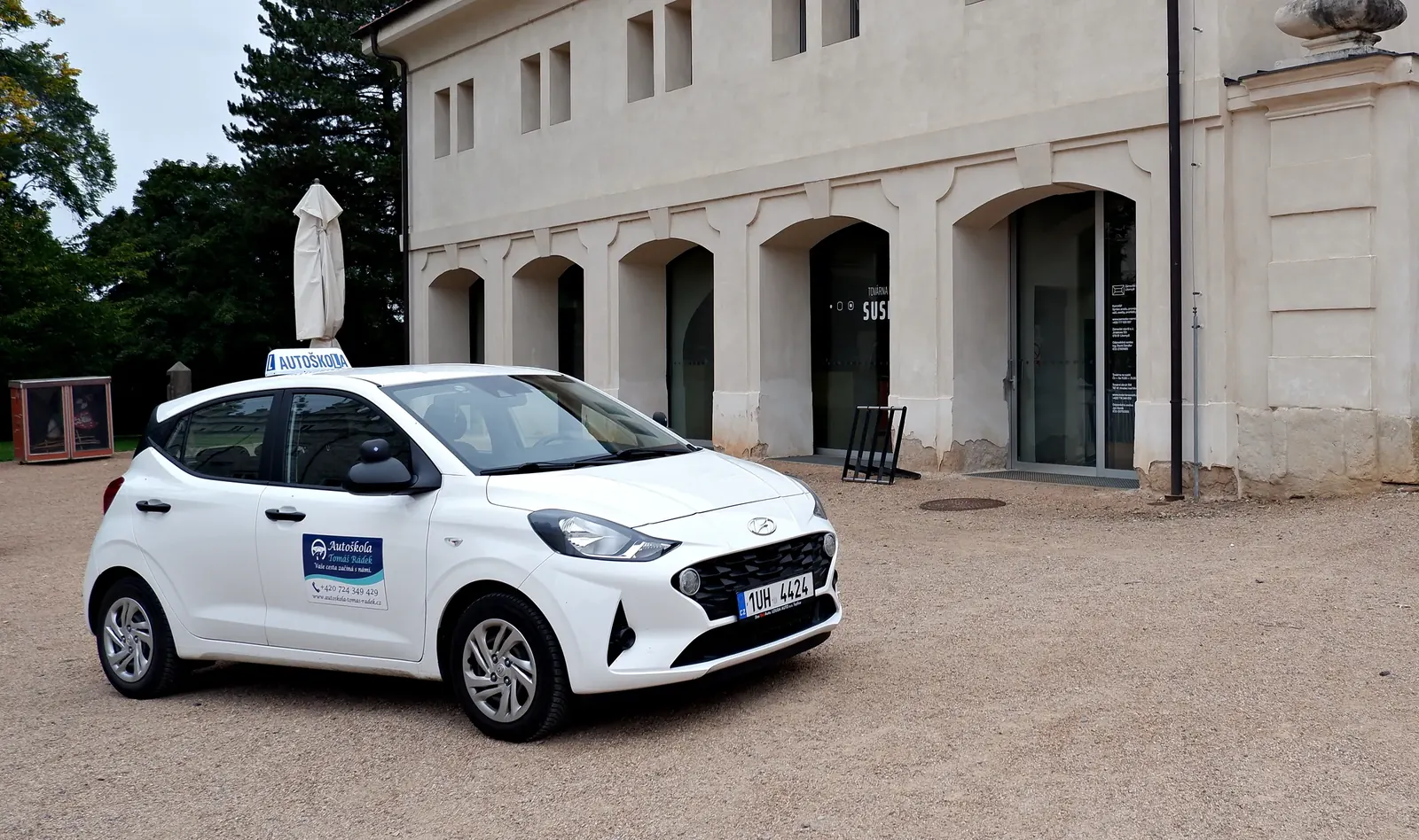 Bílý Hyundai i10 autoškoly před Kočárovnou v areálu litomyšlského zámku